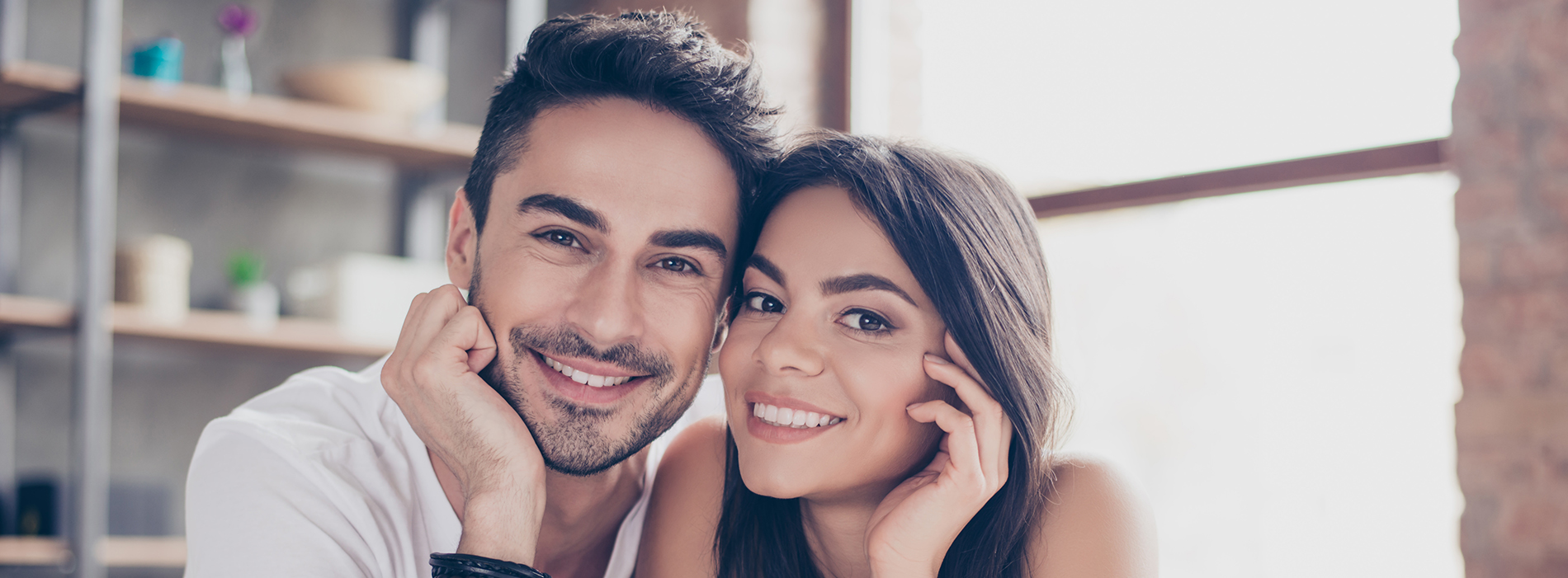 A man and woman smiling at the camera while posing together.