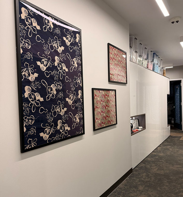 The image shows a wall displaying three framed pieces of art with intricate patterns, hanging above a white countertop.