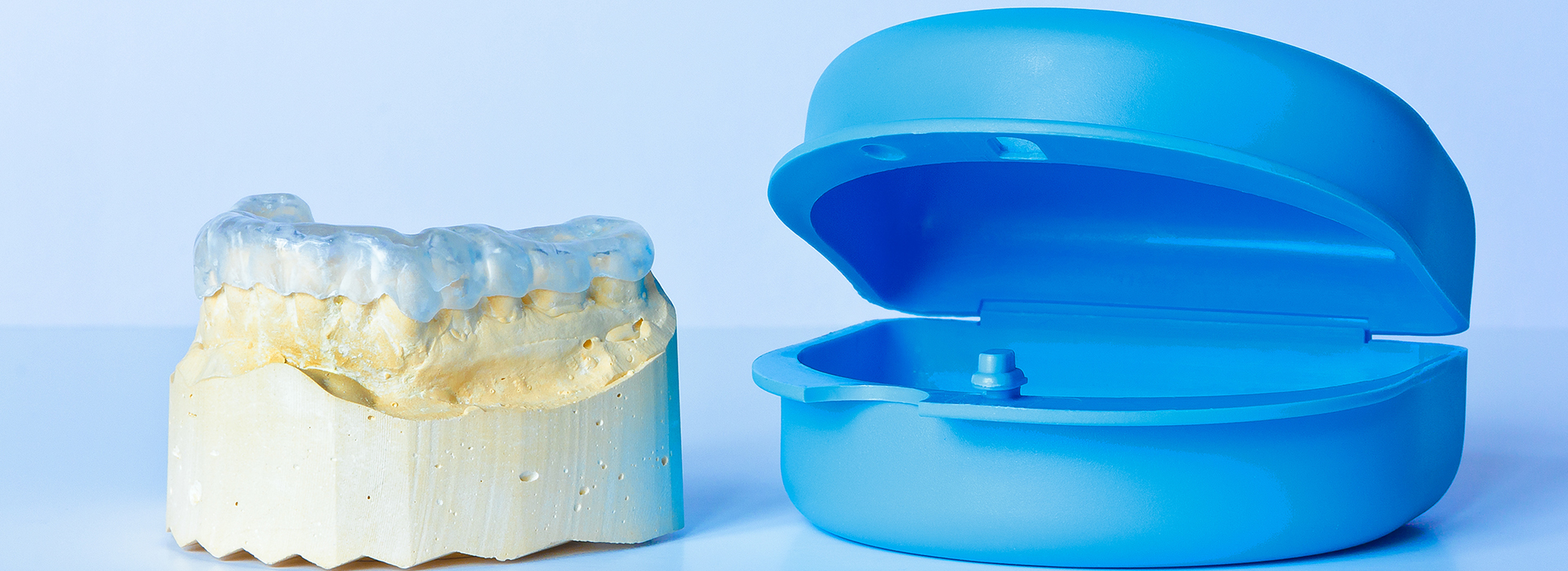 The image shows two dental implant components a yellow abutment and a blue circular ring, both set against a white background.